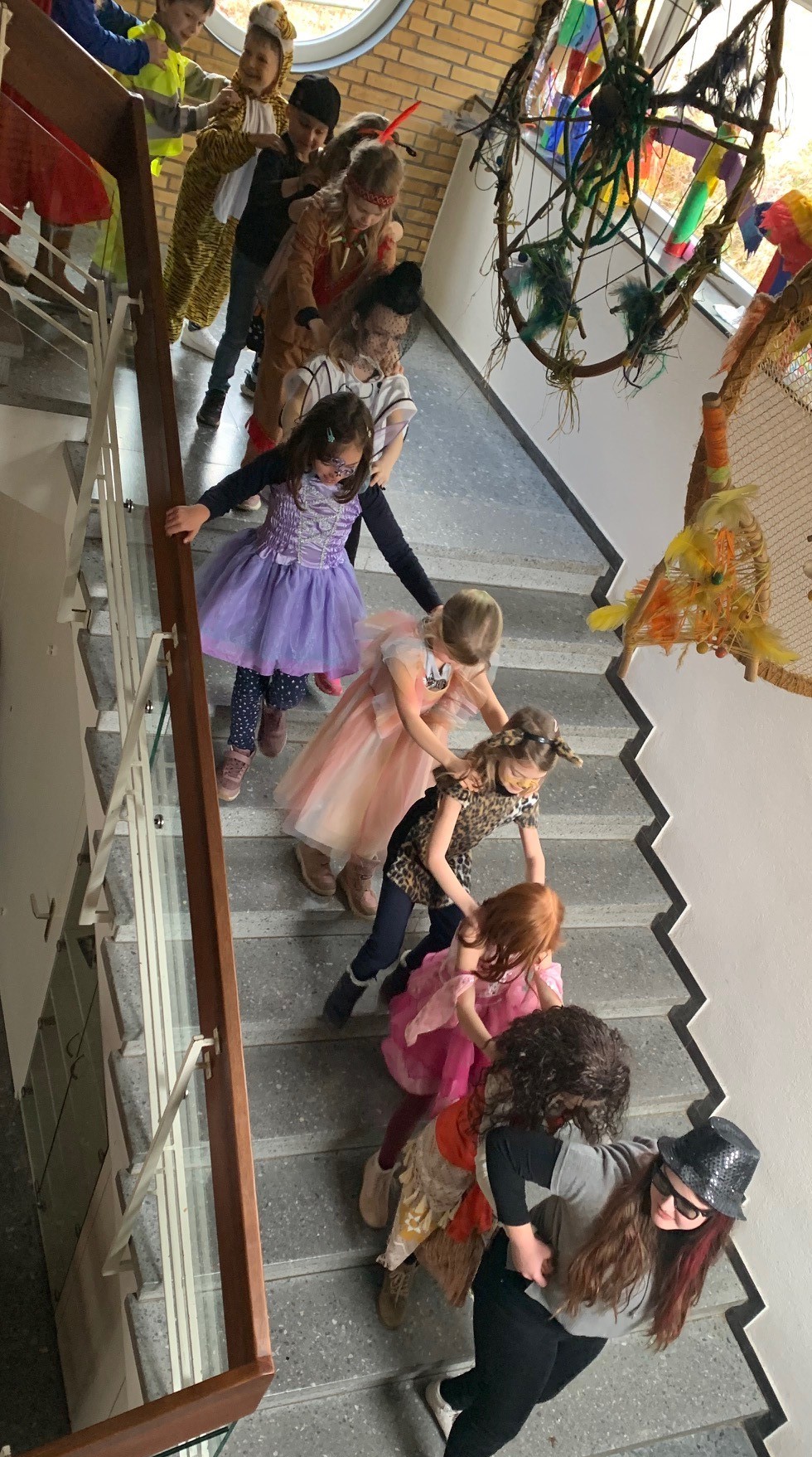 Sie Schulkinder machen eine Polonaise die Treppe hinunter.