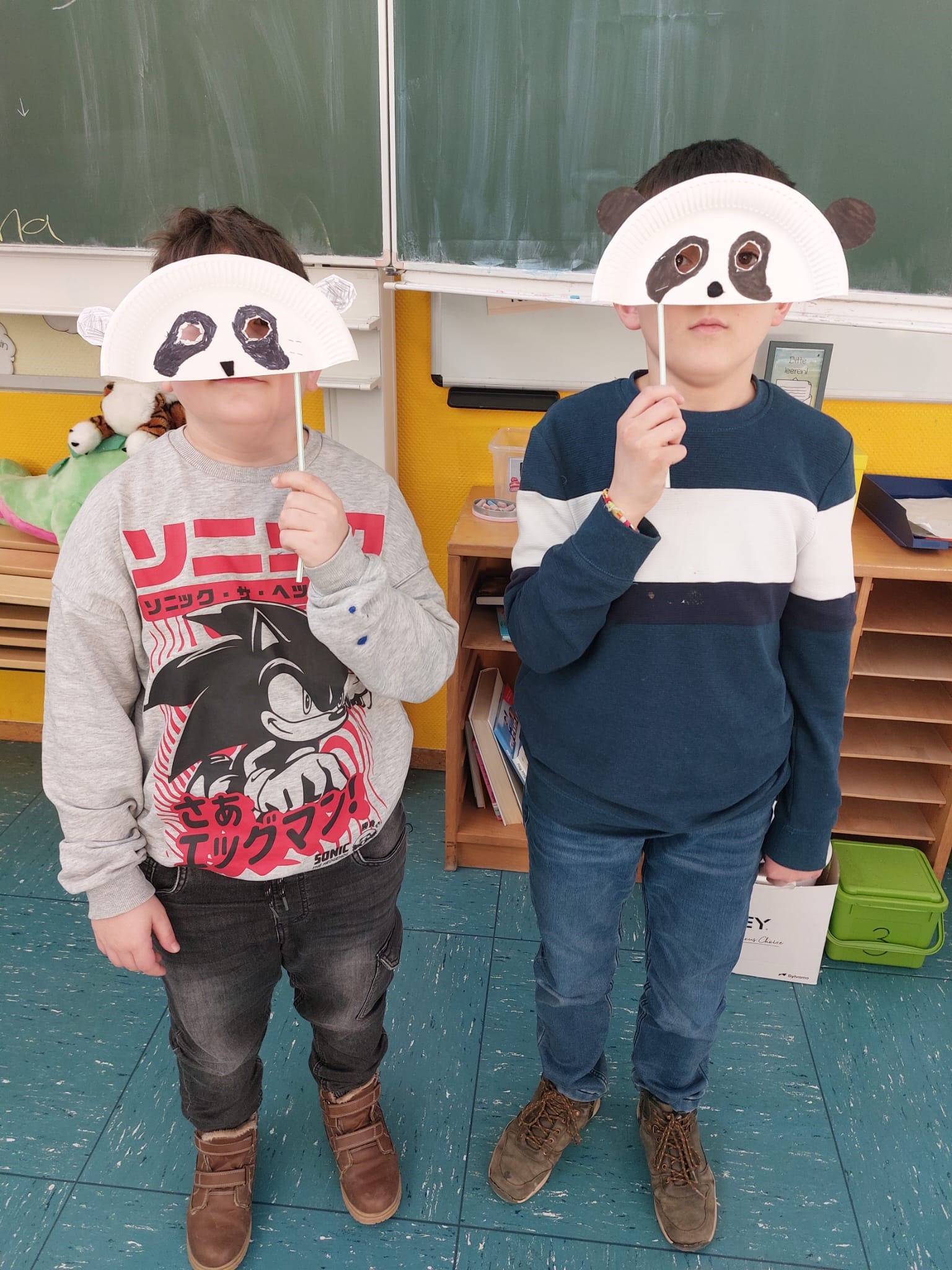 2 Kinder mit selbst gebastelten Tiermasken.