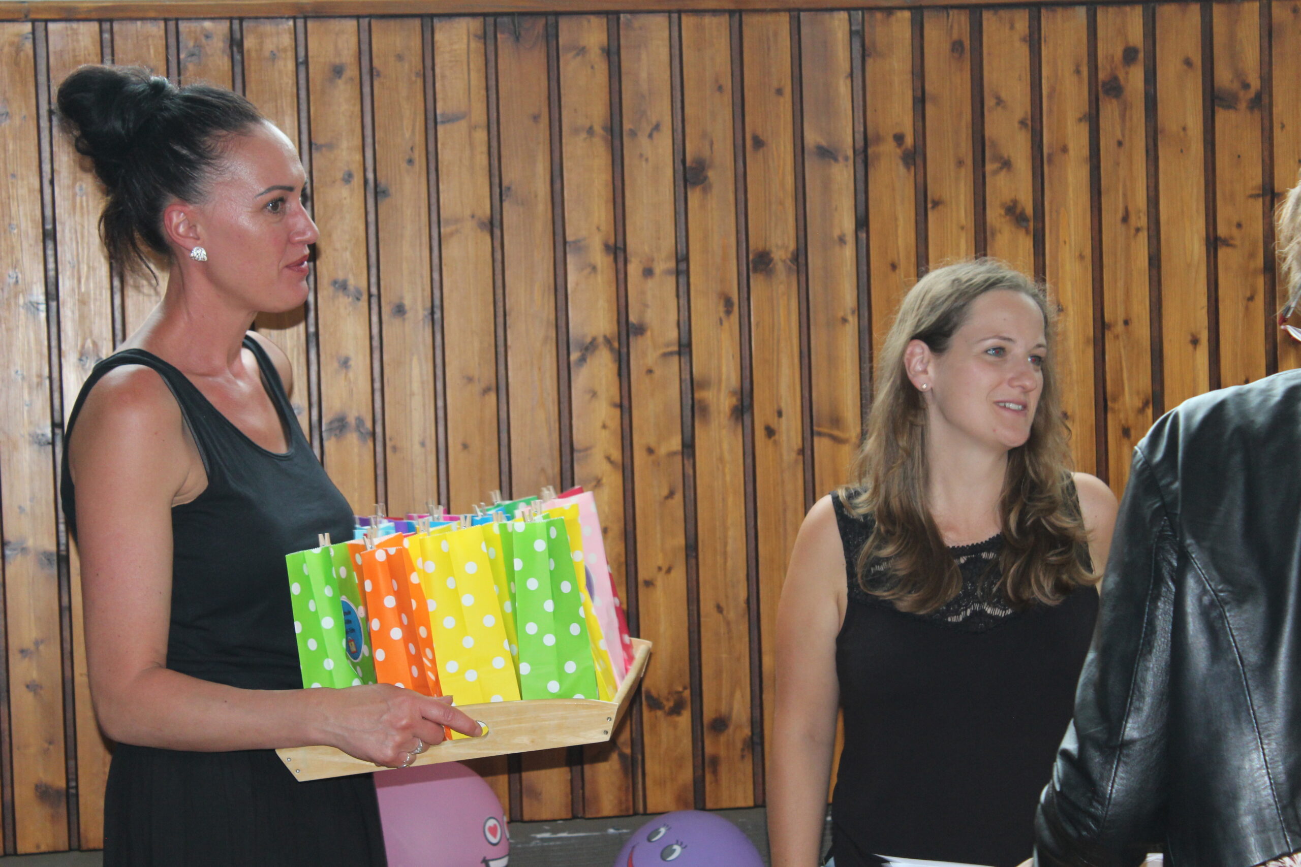 Zwei Lehrerinnen halten die Geschenke für die Kinder.
