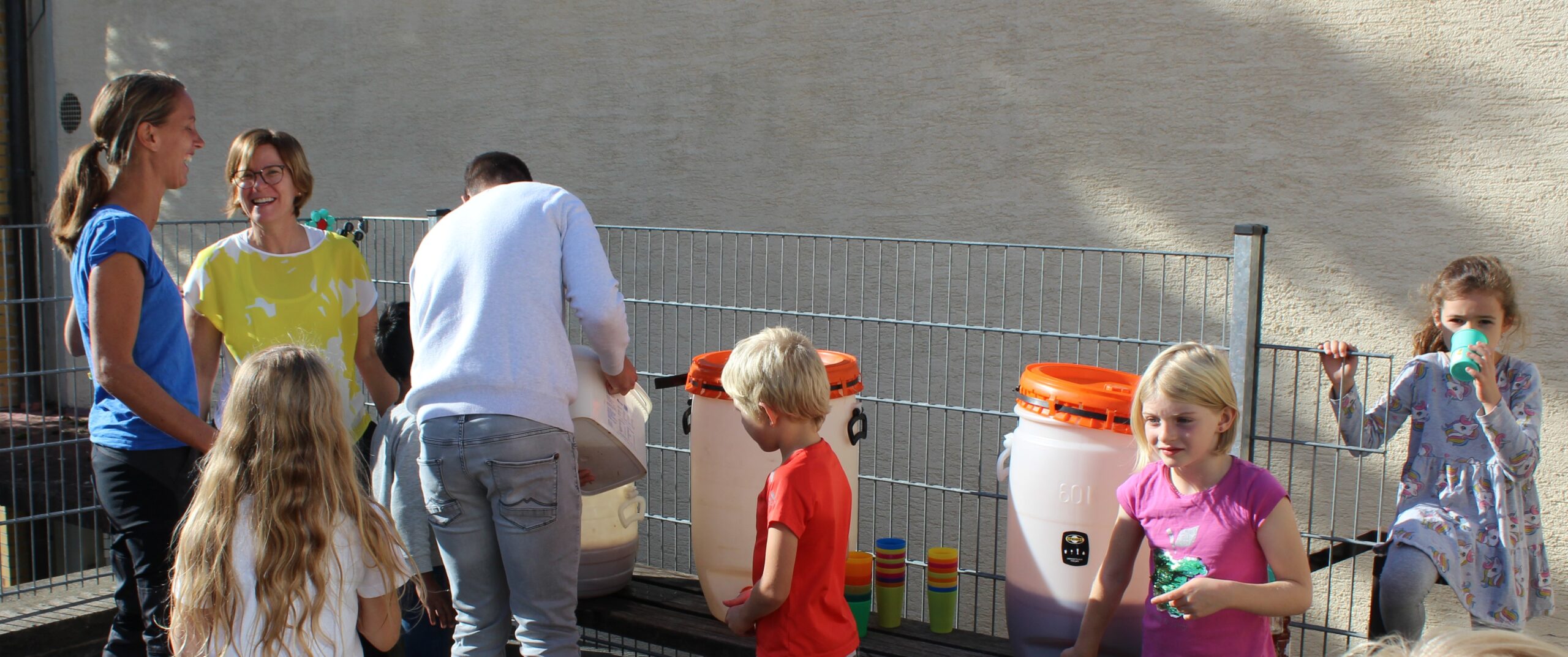 Aus Plastikbehältern wird der frisch gepresste Apfelsaft gezapft und die Kinder dürfen direkt davon trinken.