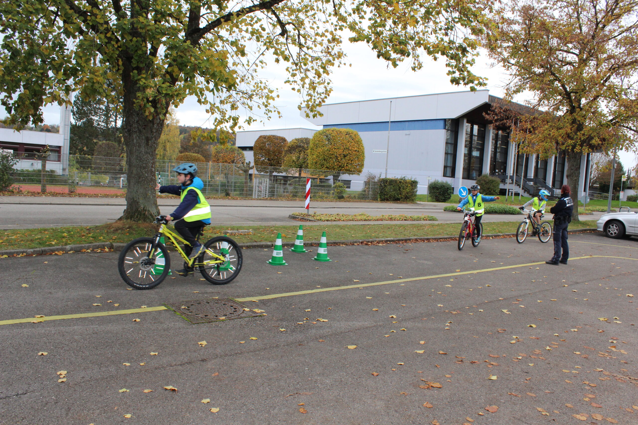 Schulkinder üben das Umfahren eines Hindernisses mit dem Fahrrad.