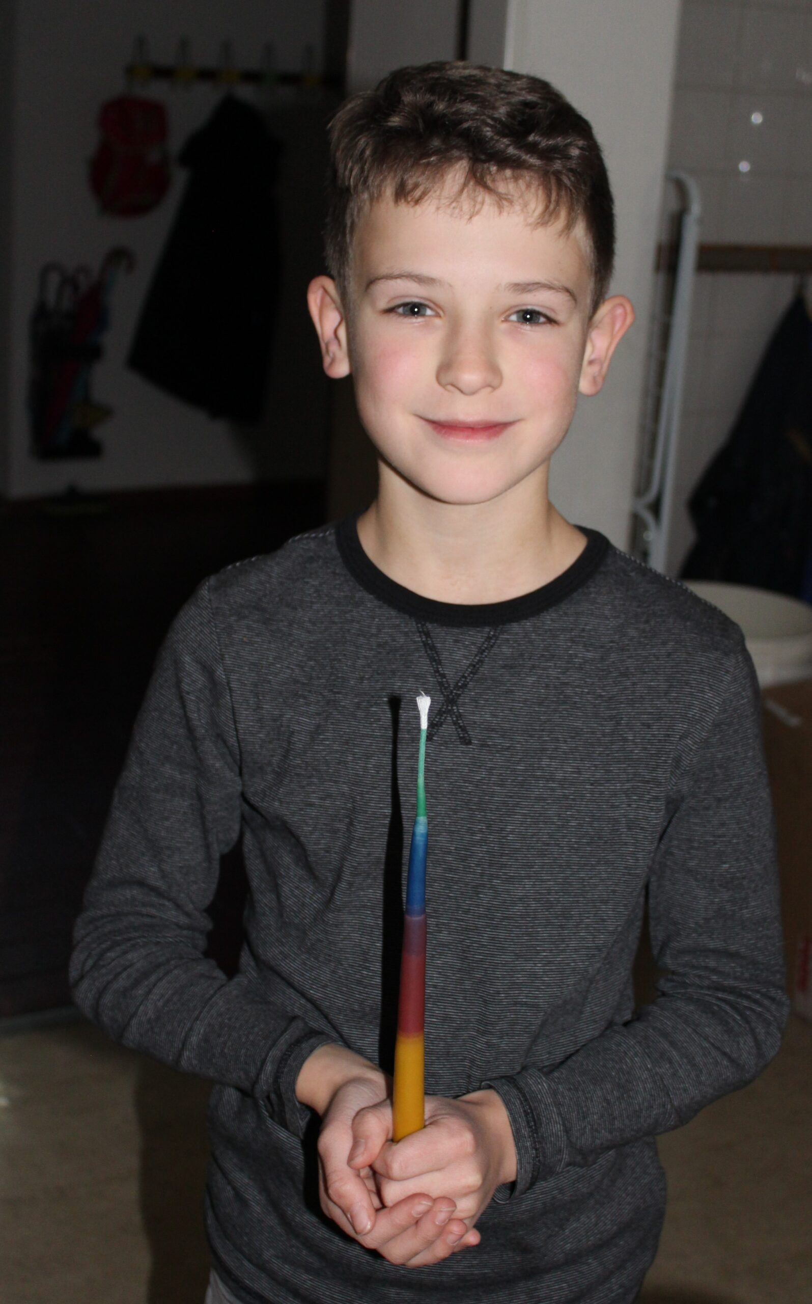 Ein Junge zeigt seine selbstgezogene Kerze.