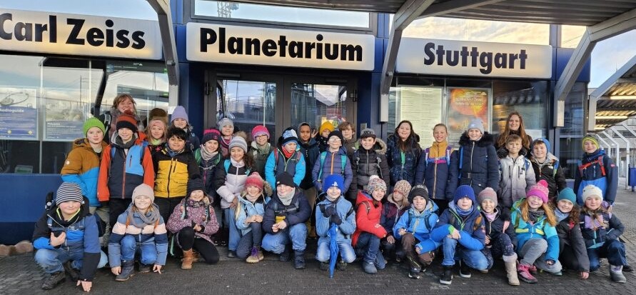 Zwei Klassen sind auf einem Gruppenbild vor dem Planetarium in Stuttgart zusehen.