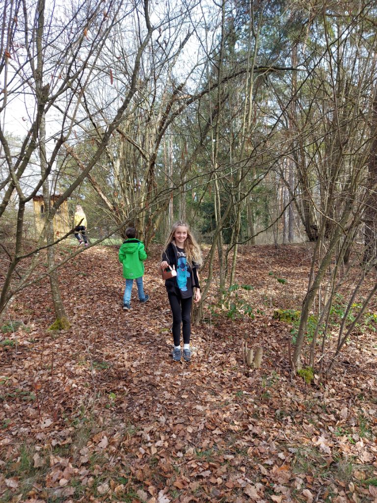 Kinder suchen in dem Naturschutzgebiet um die Schule herum nach Osternestern.