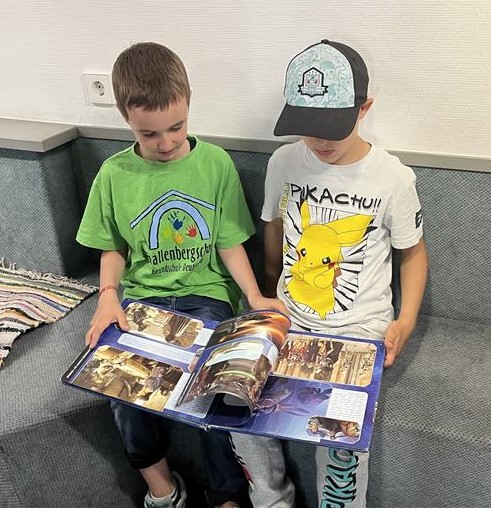 Zwei Kinder lesen gemeinsam in einem Buch.