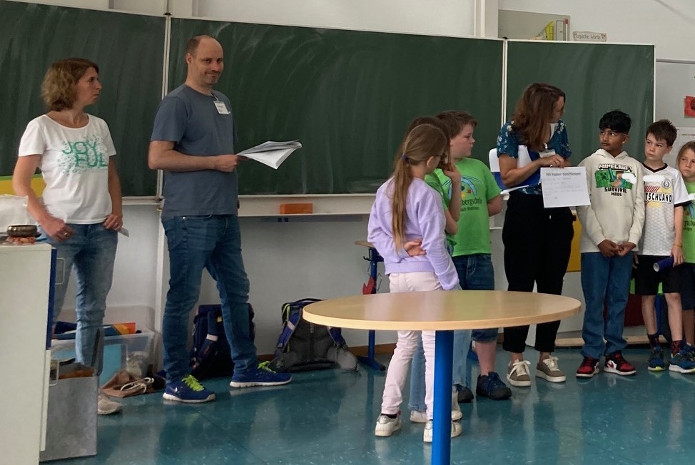 Eltern arbeiten mit Kindern in einem Klassenzimmer.