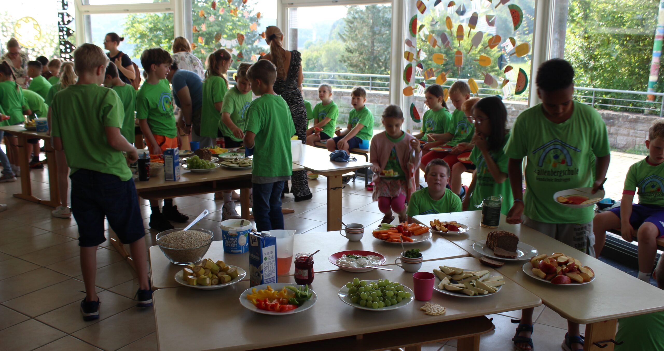 Kinder holen sich von den Frühstückstischen Essen.