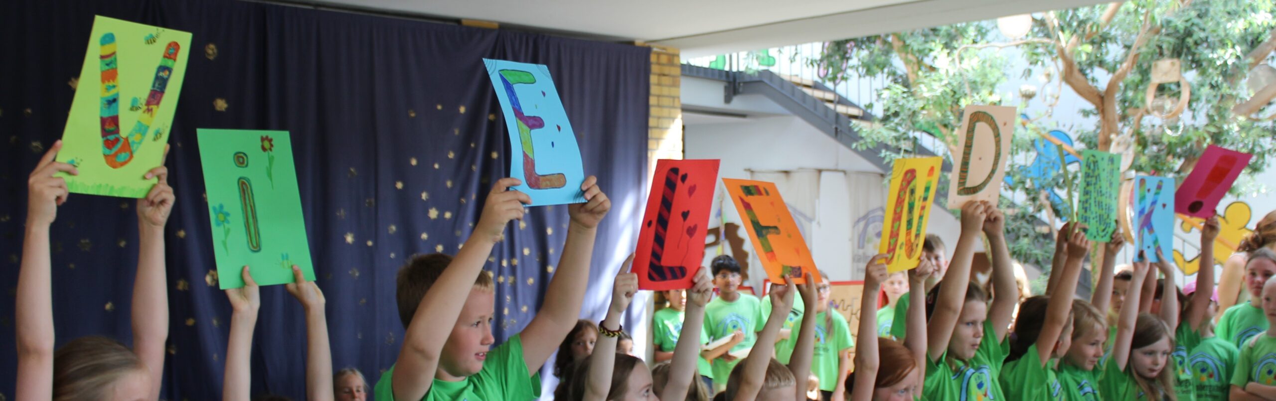 Kinder der zweiten Klasse halten Buchstaben für die Eltern hoch, auf denen Vielen Dank steht.