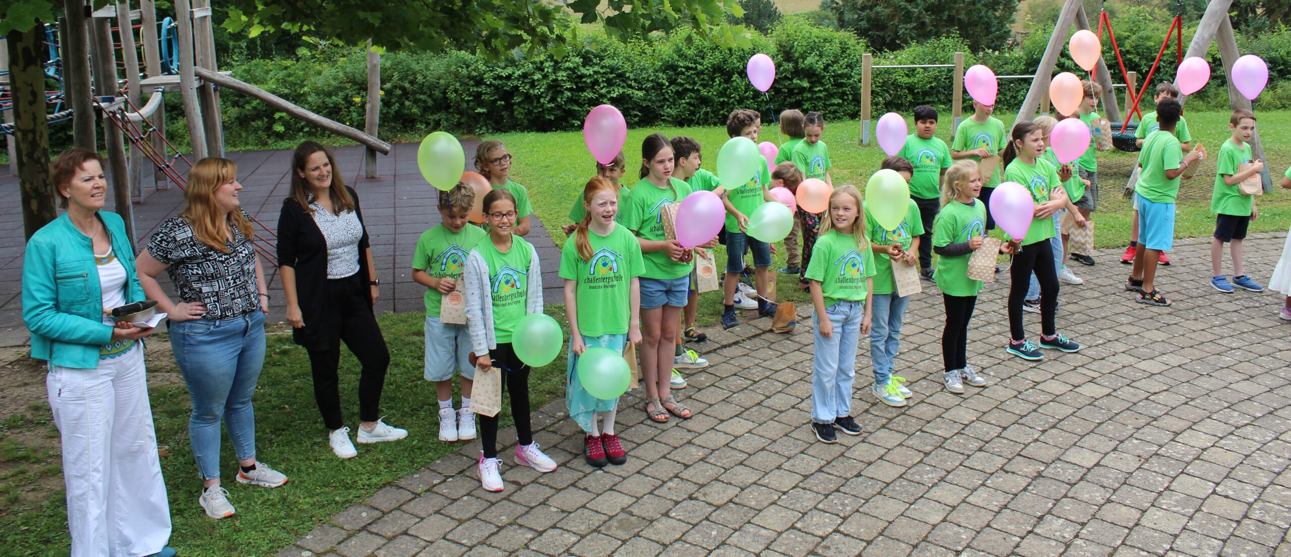 Die Viertklässler bekommen ein Abschiedsgeschenk und einen Luftballon.