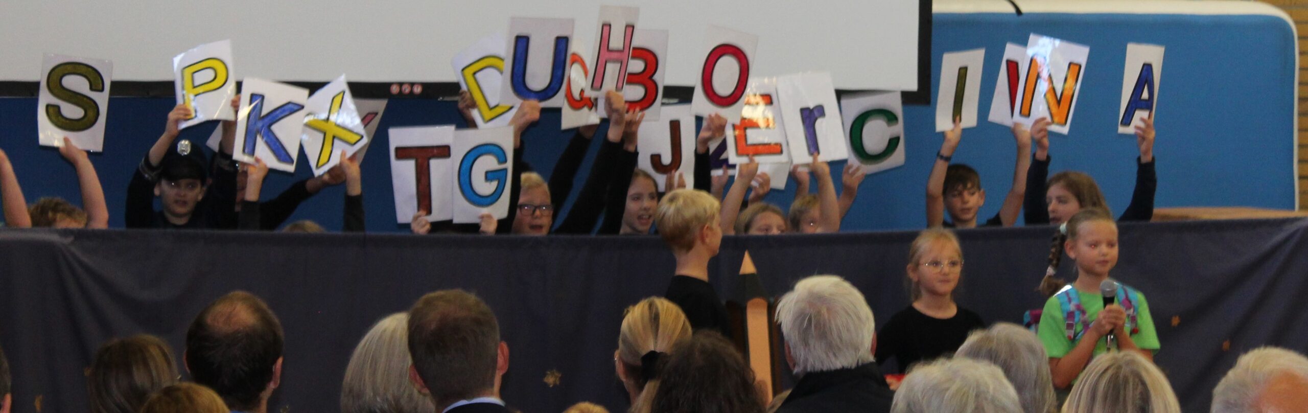 Kinder spielen ein Theaterstück mit Buchstaben vor.