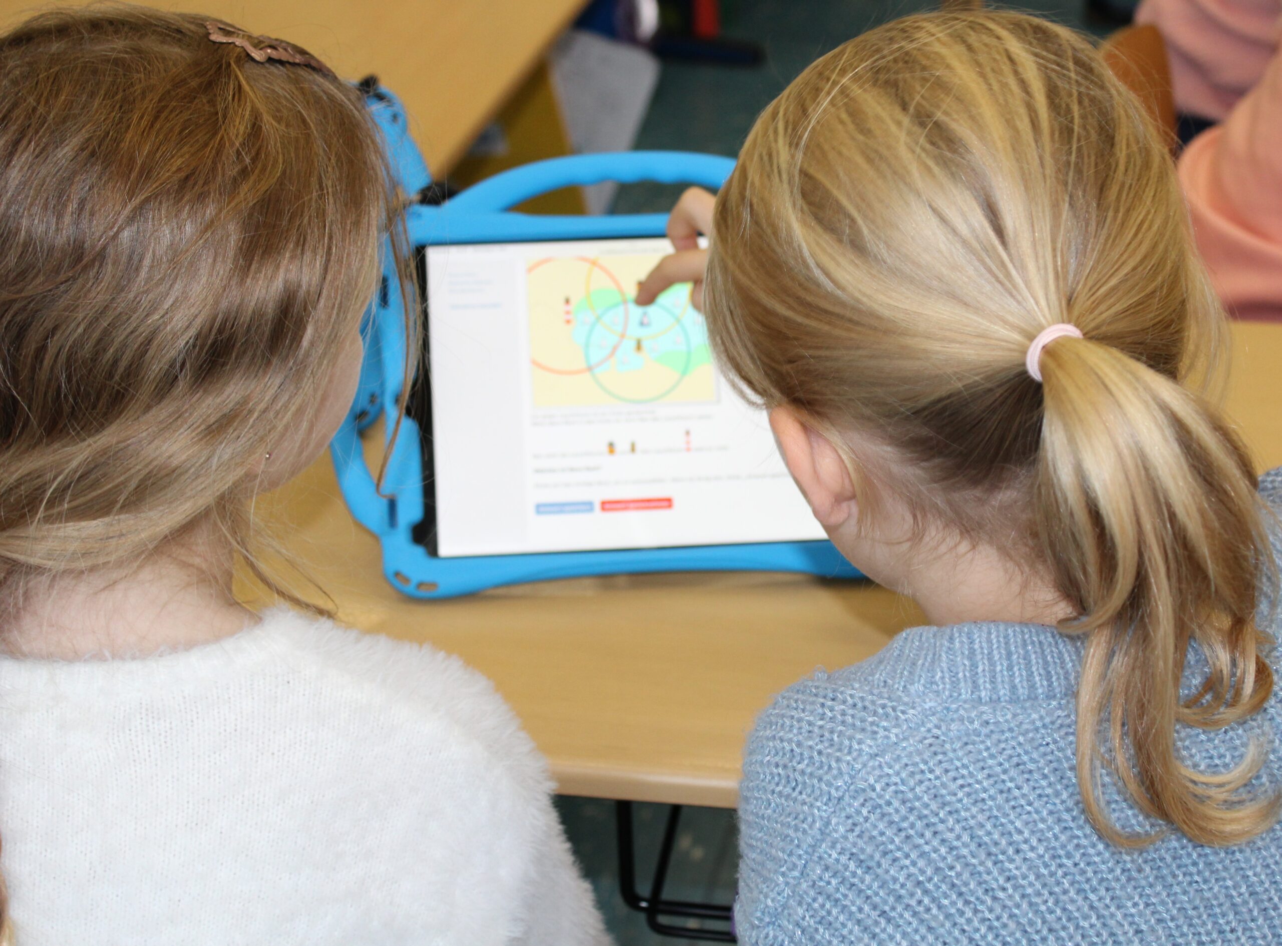 Kinder arbeiten im Klassenzimmer an den iPads.