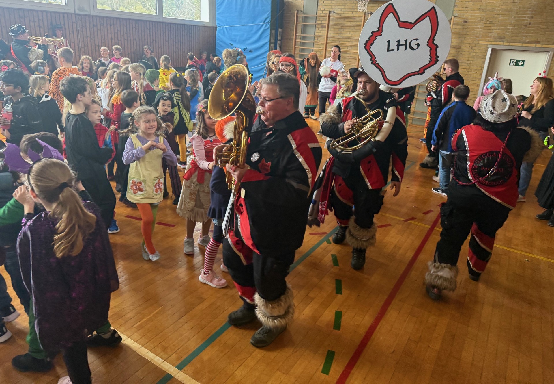 In der Sporthalle laufen die Langhoorguggis mit ihren Instrumenten rum und spielen.