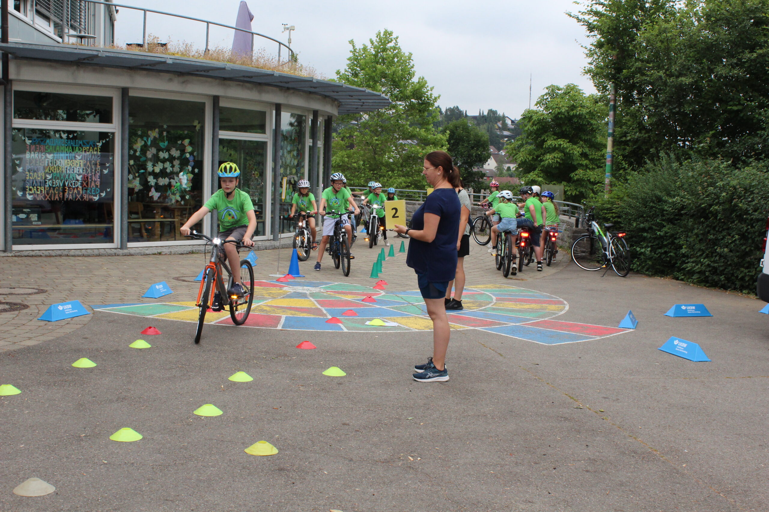 auf dem Schulhof, Junge auf Fahrrad, Slalomhütchen auf dem Boden,