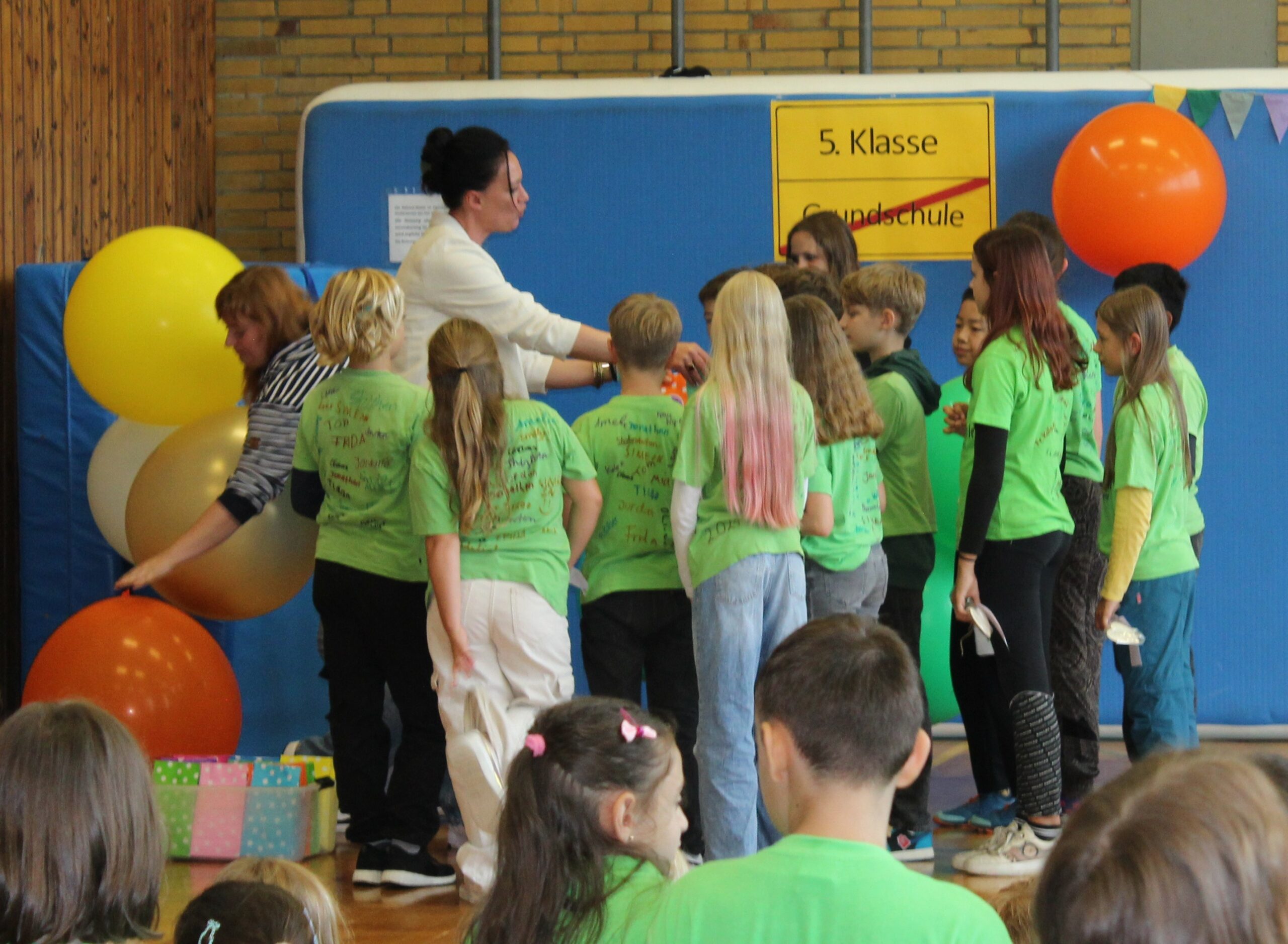 Eine Klassenlehrerin der Vierer übergibt jedem Einzelnen ein Abschiedsgeschenk.