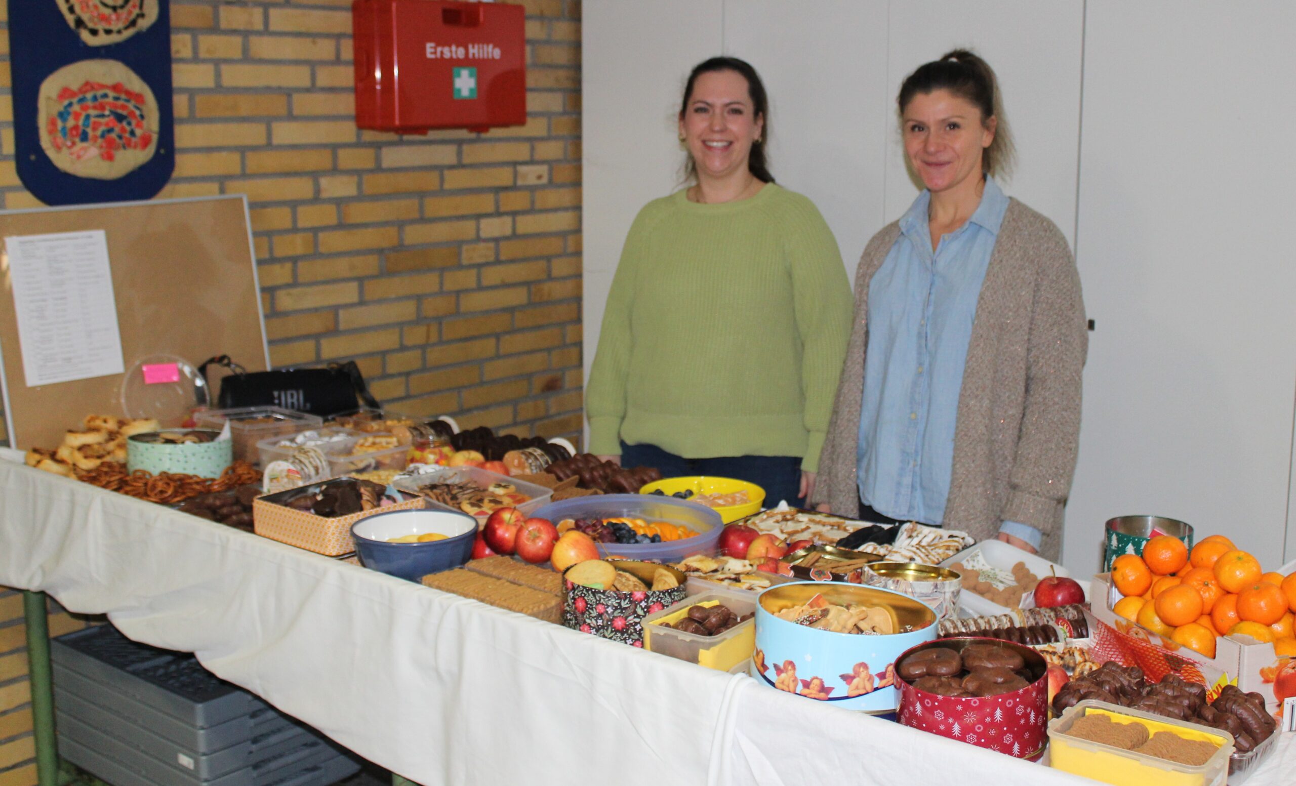 Hier stehen Eltern beim Plätzchenbuffet.