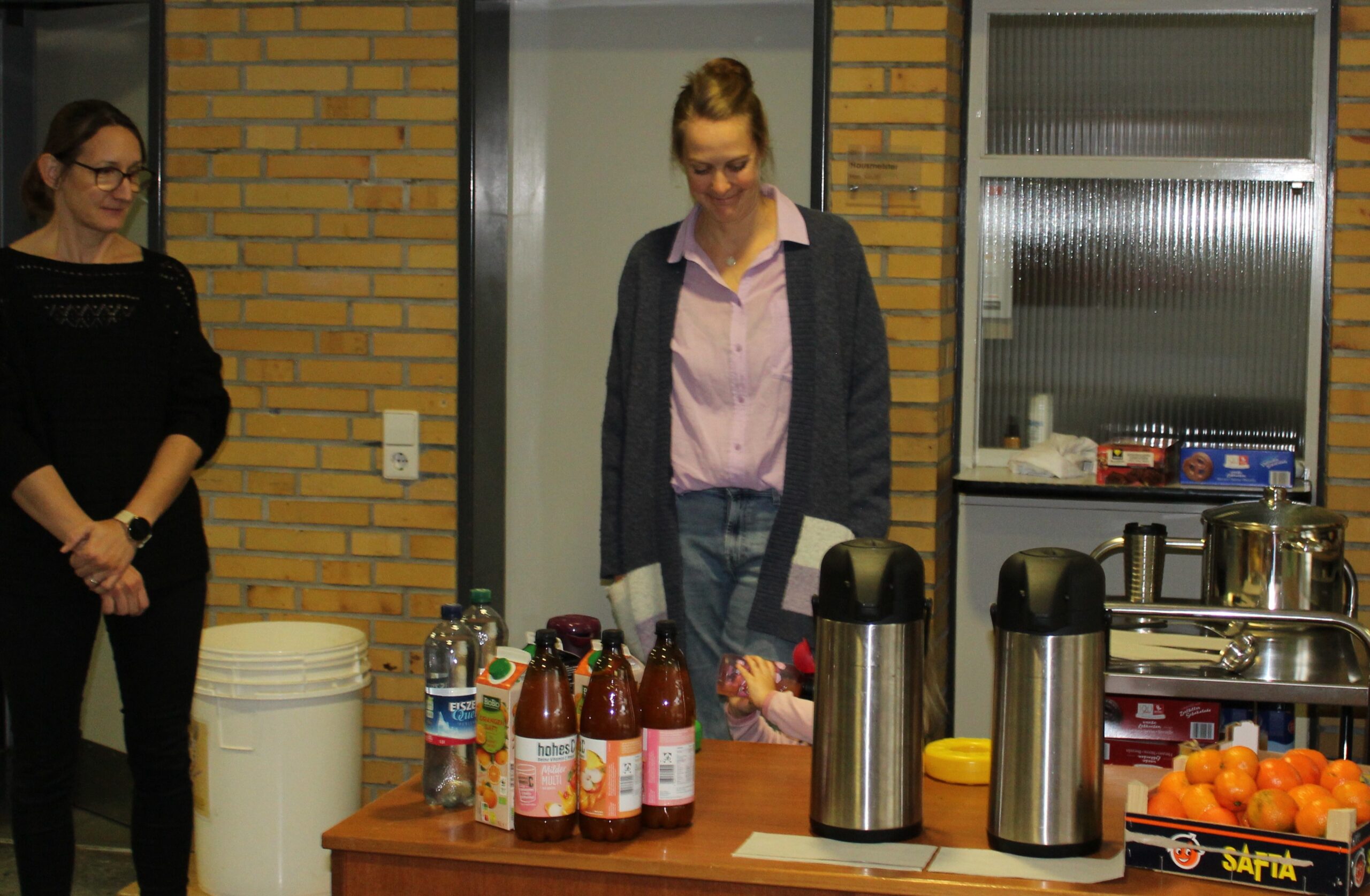 Eltern stehen beim Punsch und bei den Getränken.