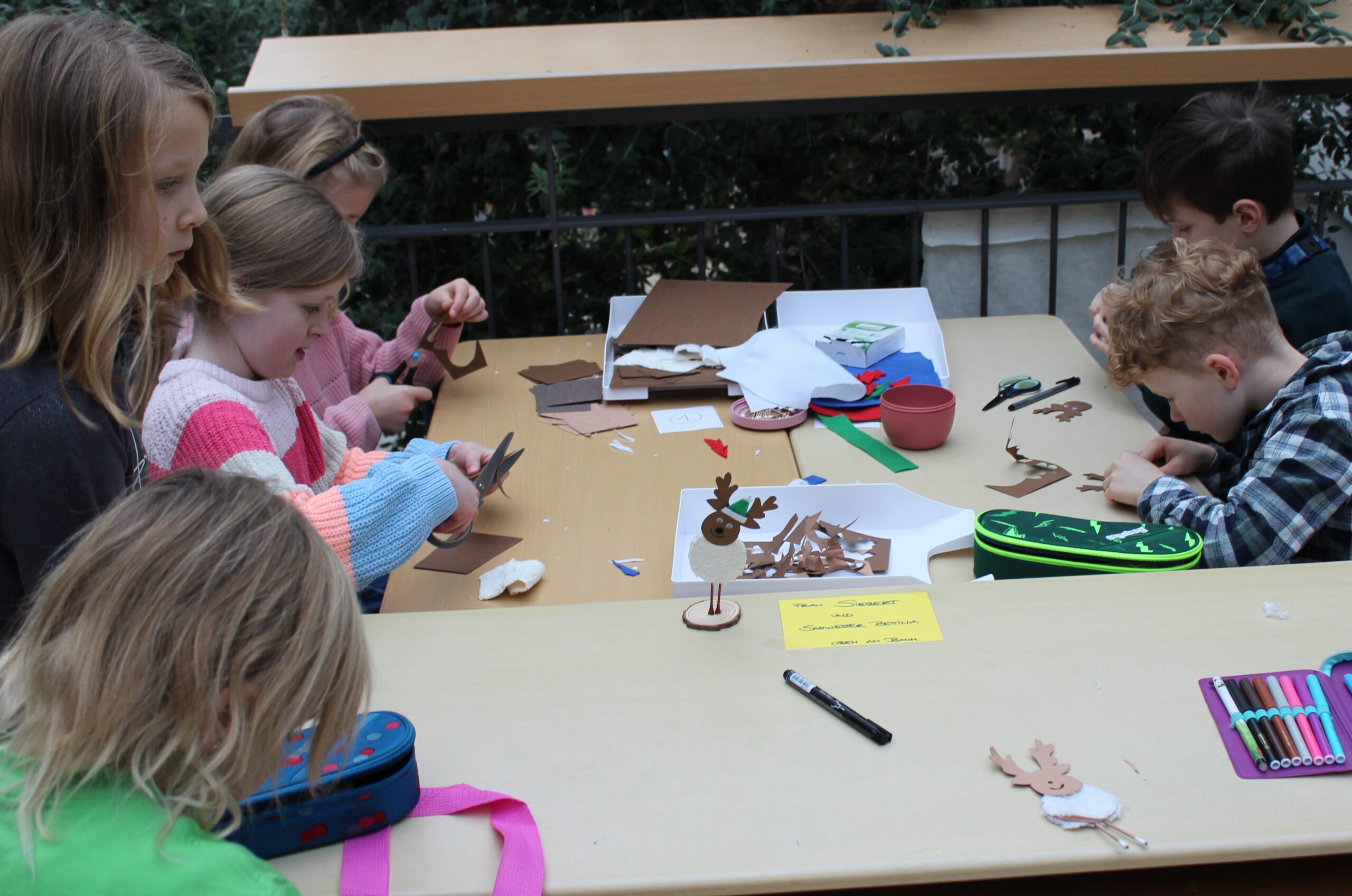 Hier basteln Kinder Elche auf Ständern mit Fell.