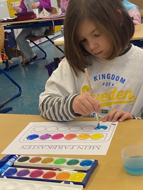 Ein Mädchen probiert ihren Wasserfarbenkasten aus.