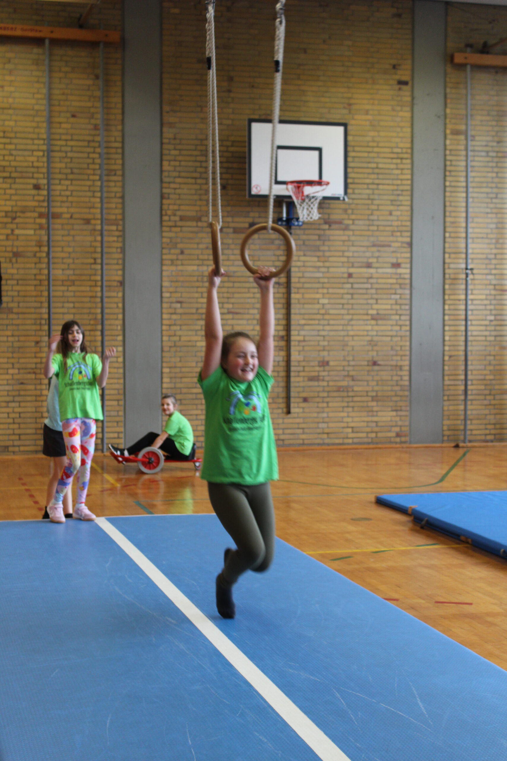 Ein Mädchen schwingt an den Ringen.