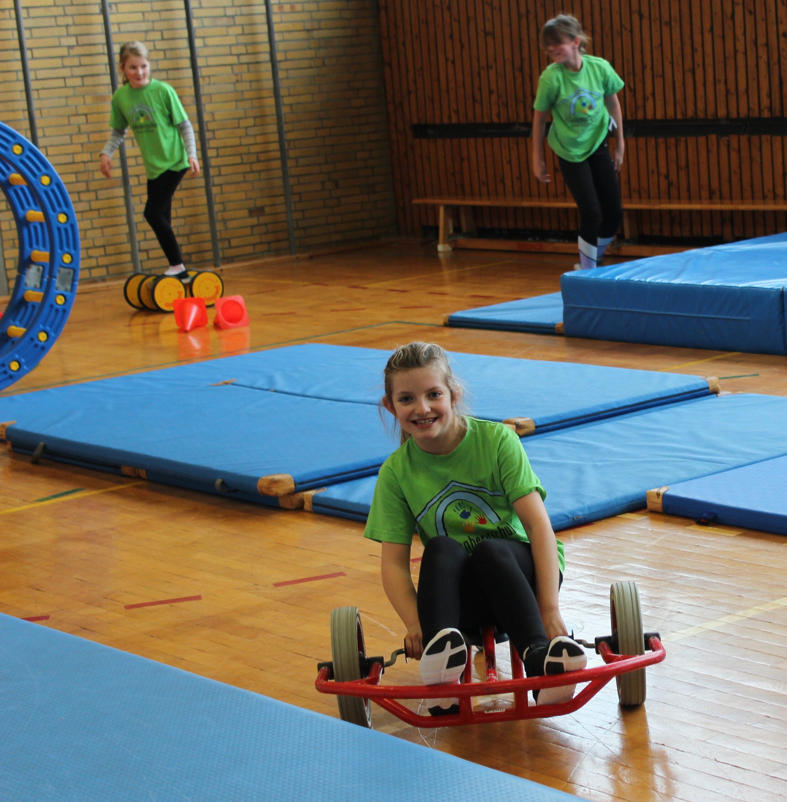 Ein Mädchen fährt auf einem Hand-Tret-Roller.