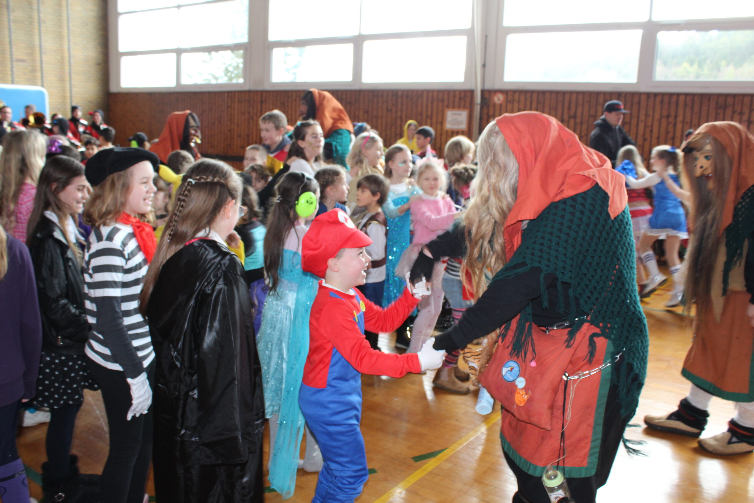 Ein Hexe tanzt mit einem Jungen.