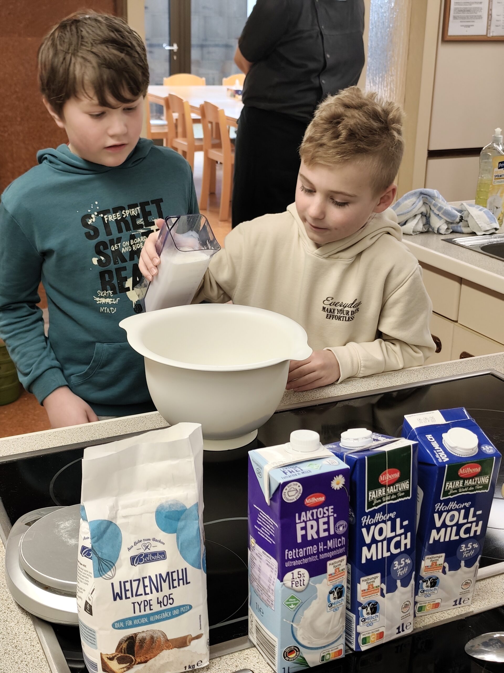 Zwei Jungen bereiten etwas in der Schulküche zu.
