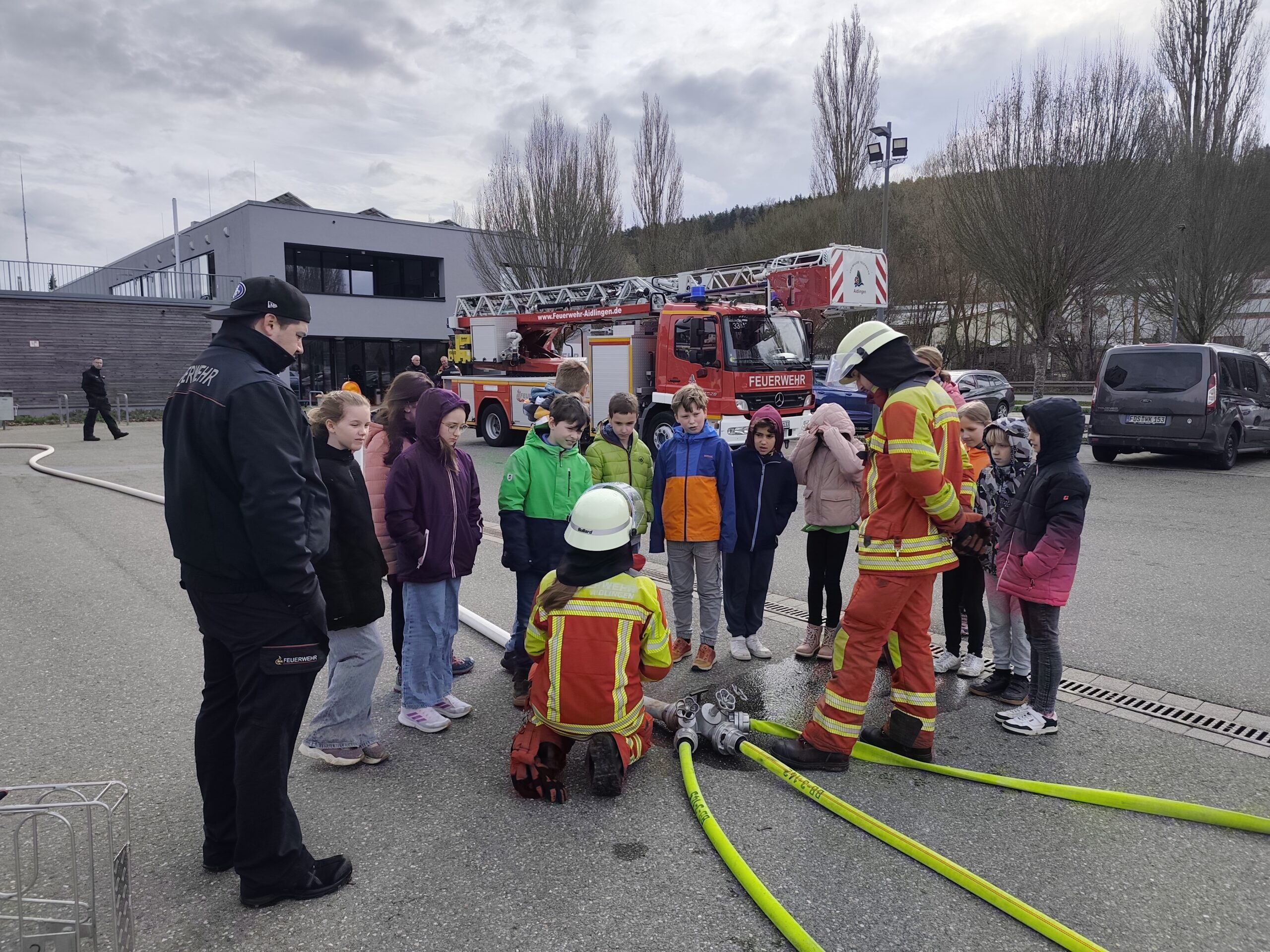 Den Kindern wird bei der Feuerwehr den Einsatz der Schläuche gezeigt.