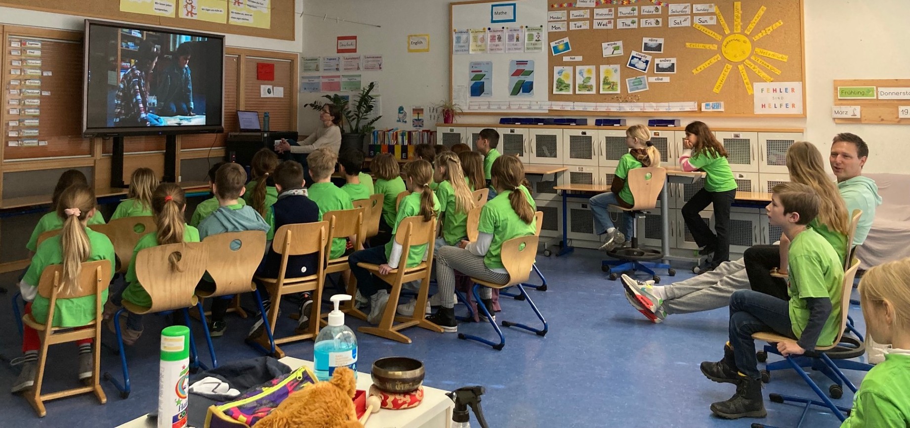 Eine Schulklasse schaut einen Kurzfilm auf dem Panel.