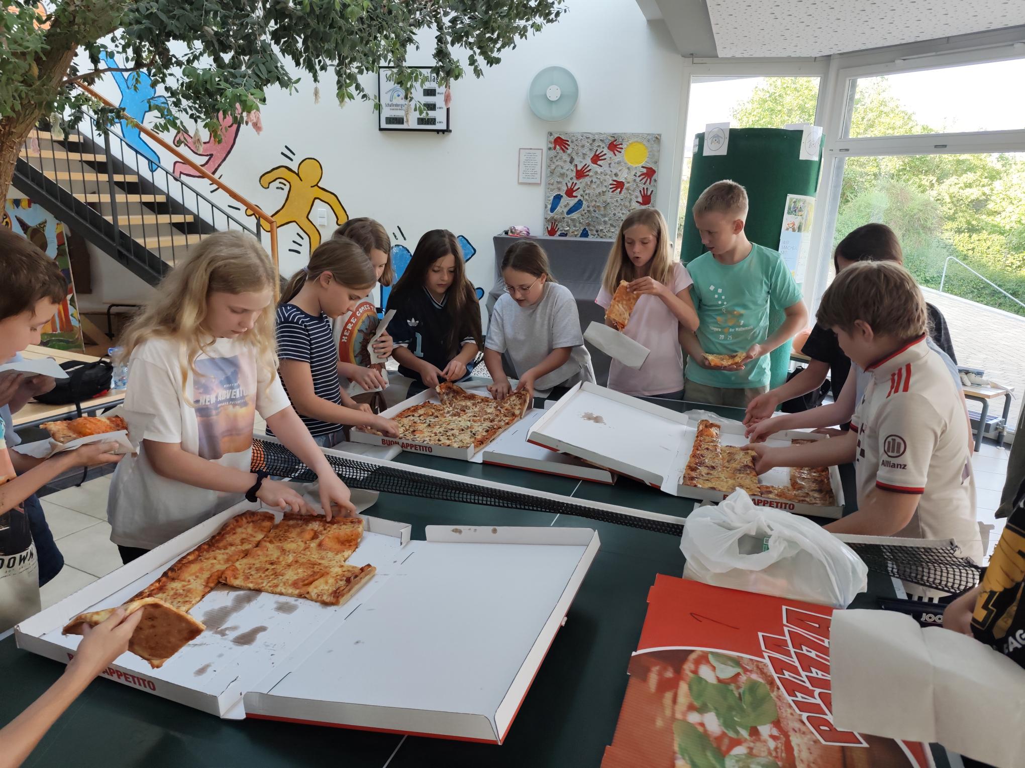 Viertklässler freuen sich über ein gemeinsames Pizzaabendessen.