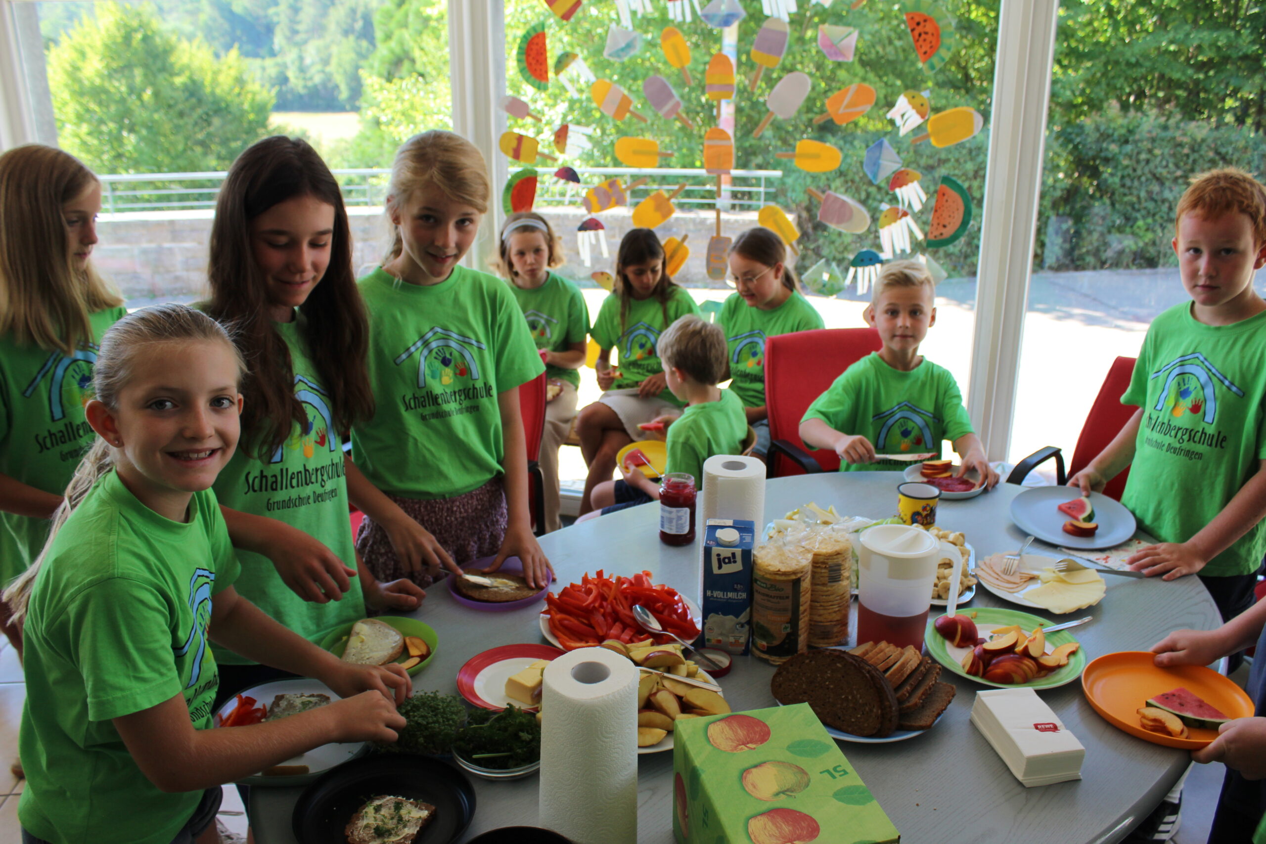 Kinder bedienen sich an den Tischen mit den frischen Zutaten vom gesunden Frühstück.