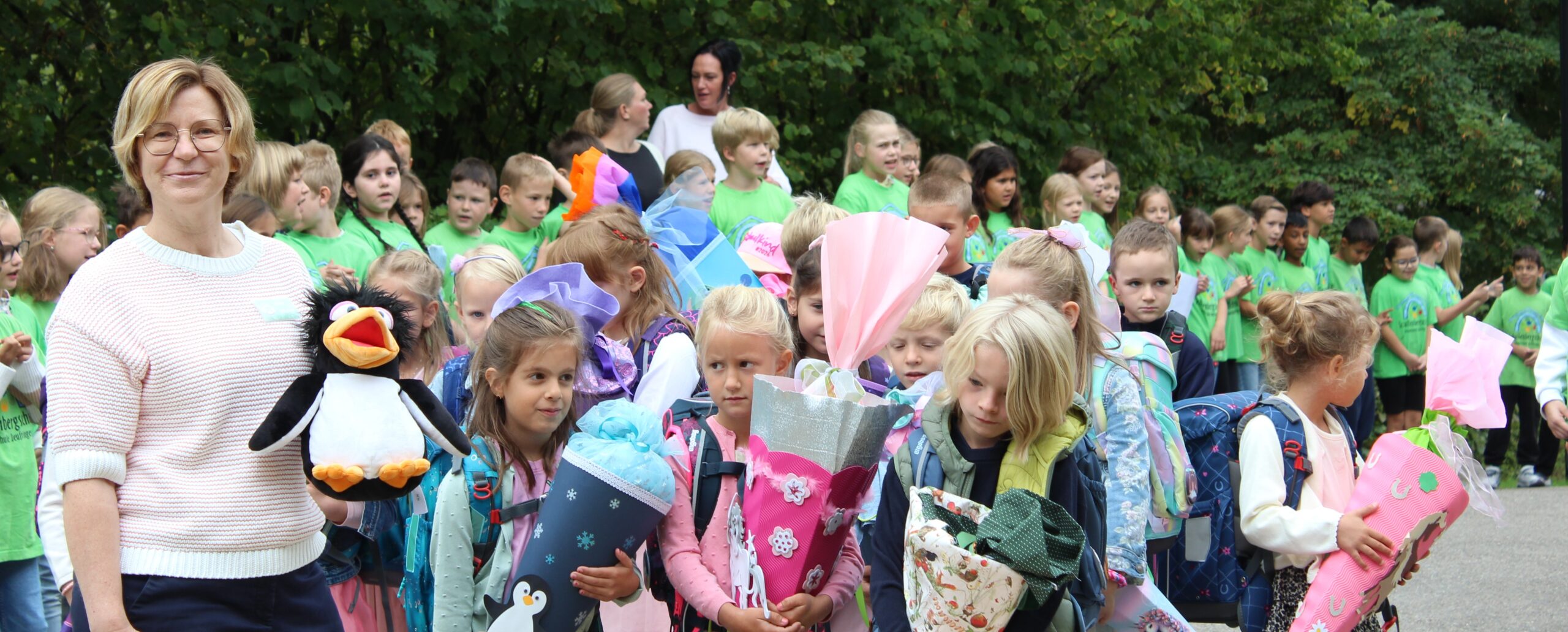 Die Klasse 1b wird von der Schulgemeinschaft empfangen und ins Schulhaus gebeten.